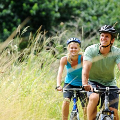 Happy couple riding bicycles outside, healthy lifestyle fun concept