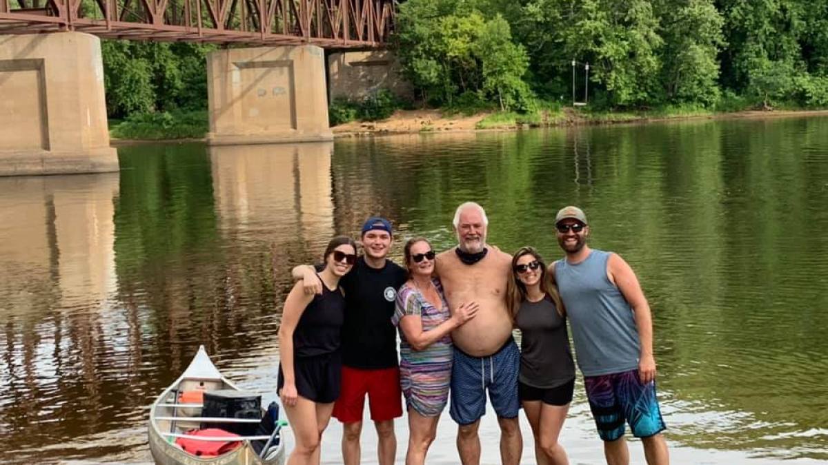 a group of people standing next to a body of water